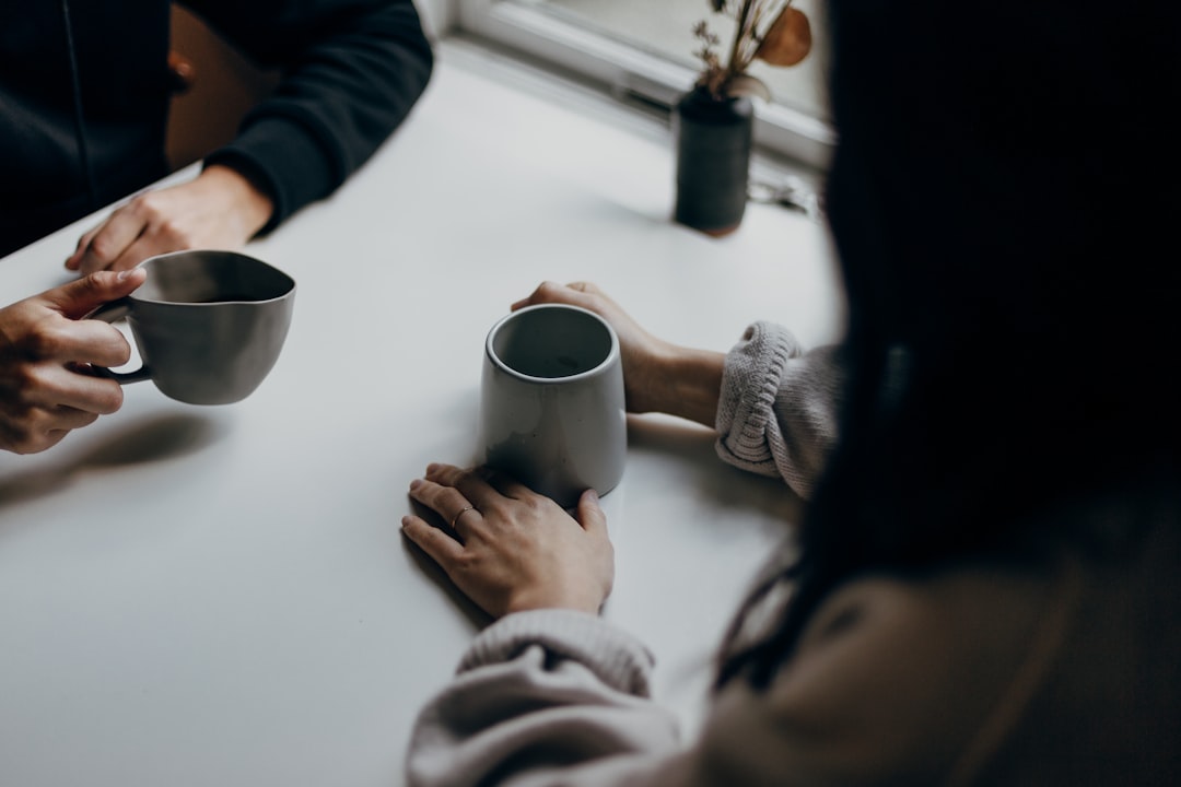 Iemand in je omgeving blowt: twee mensen in een rustig ondersteunend gesprek met koffie